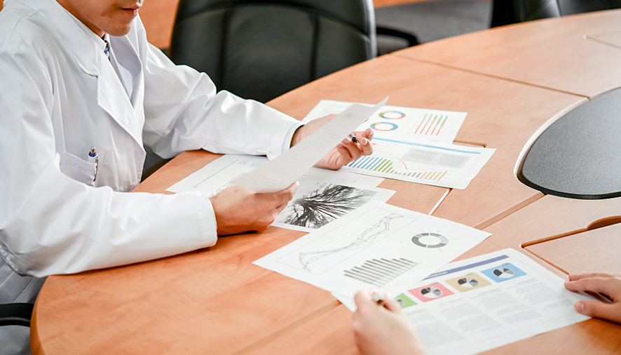 書類を見ながら打合せする医師